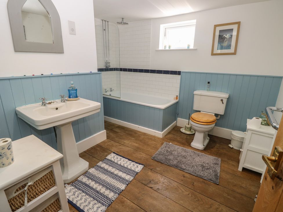 A bathroom with a sink, bathtub, and toilet at Guildford Farmhouse in Ryde