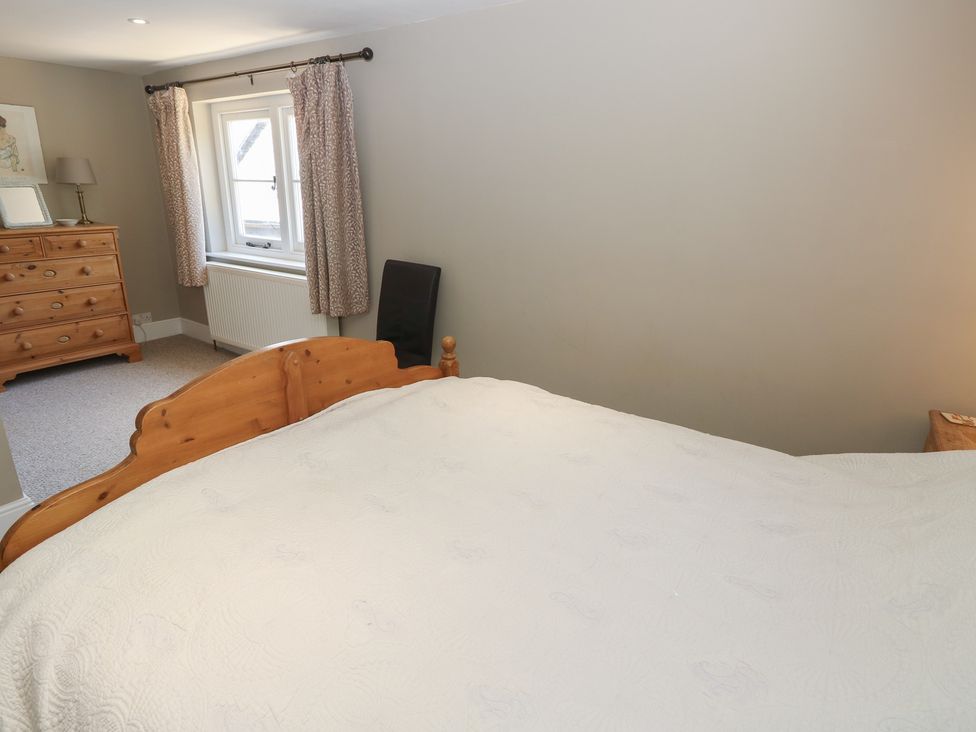 A bedroom with a bed, dresser, and window at Guildford Farmhouse in Ryde