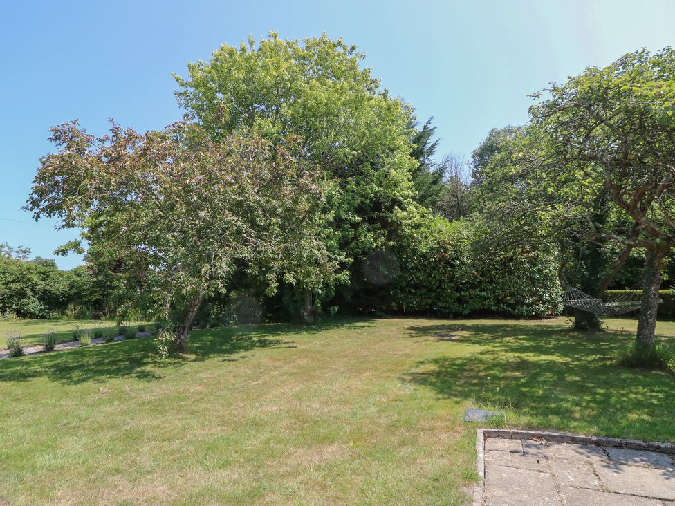 A garden with trees and a hammock at Guildford Farmhouse in Ryde