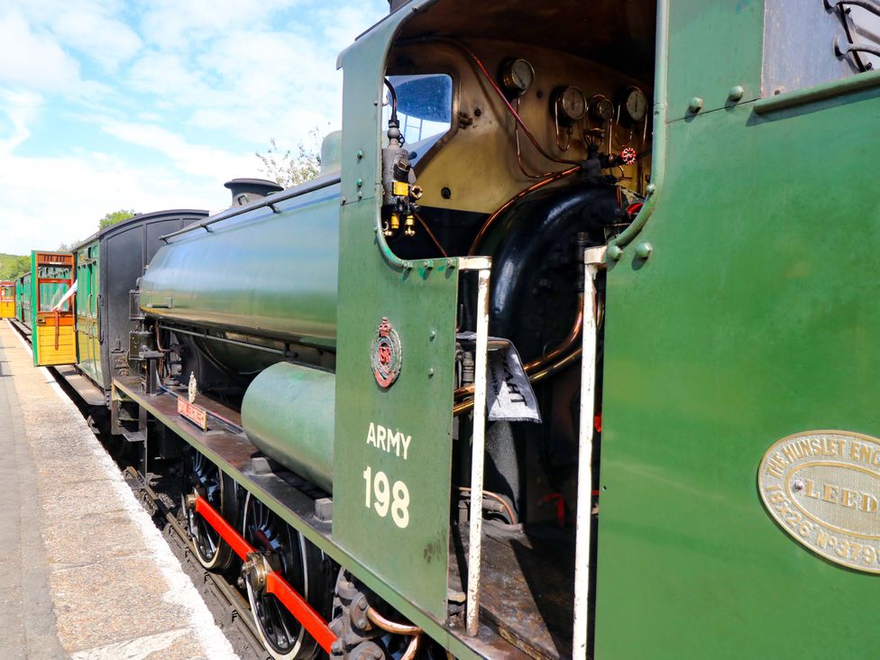 A steam engine with a coal tender at a railway station