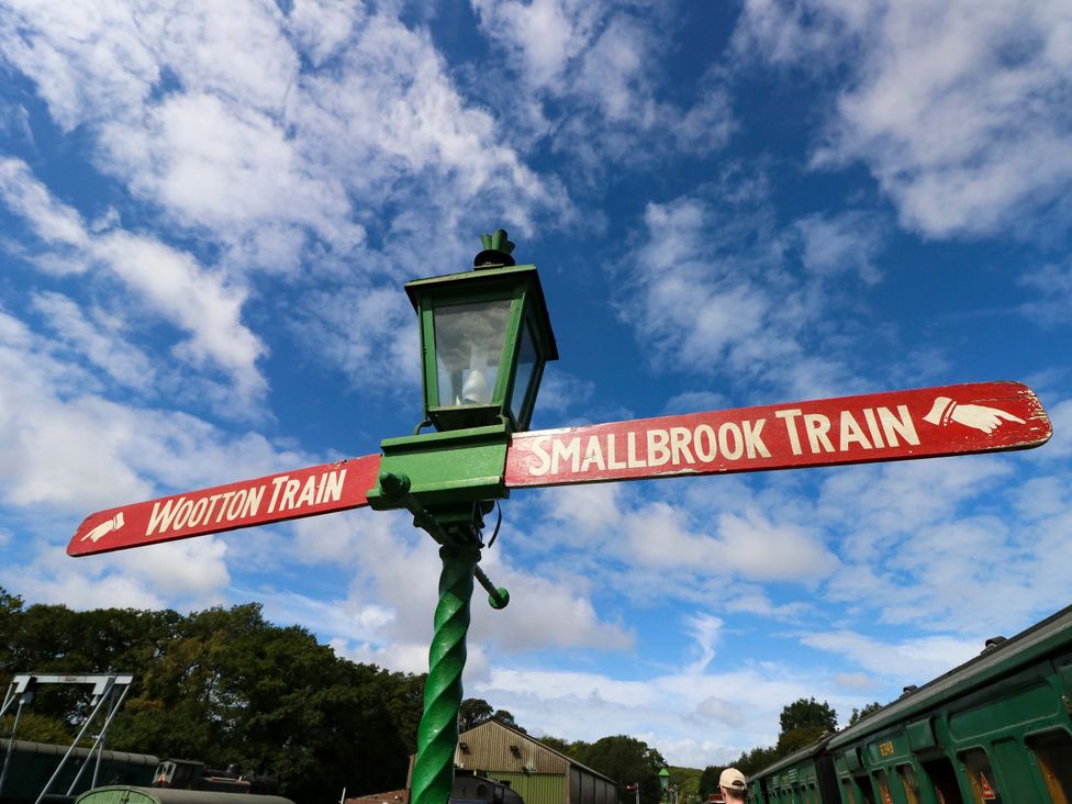 A signpost for Wootton Train and Smallbrook Train at a railway station