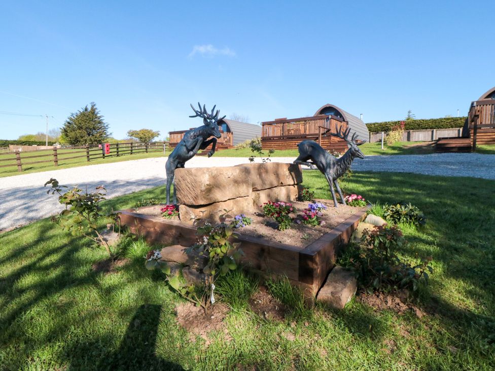 An outdoor area with deer sculptures and a stone planter at Aspen Lodge in Whitby