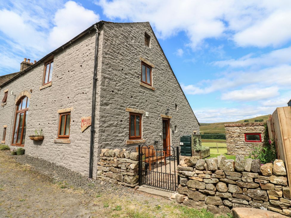 A stone cottage with windows and a door at Middlefell View Cottage in Alston