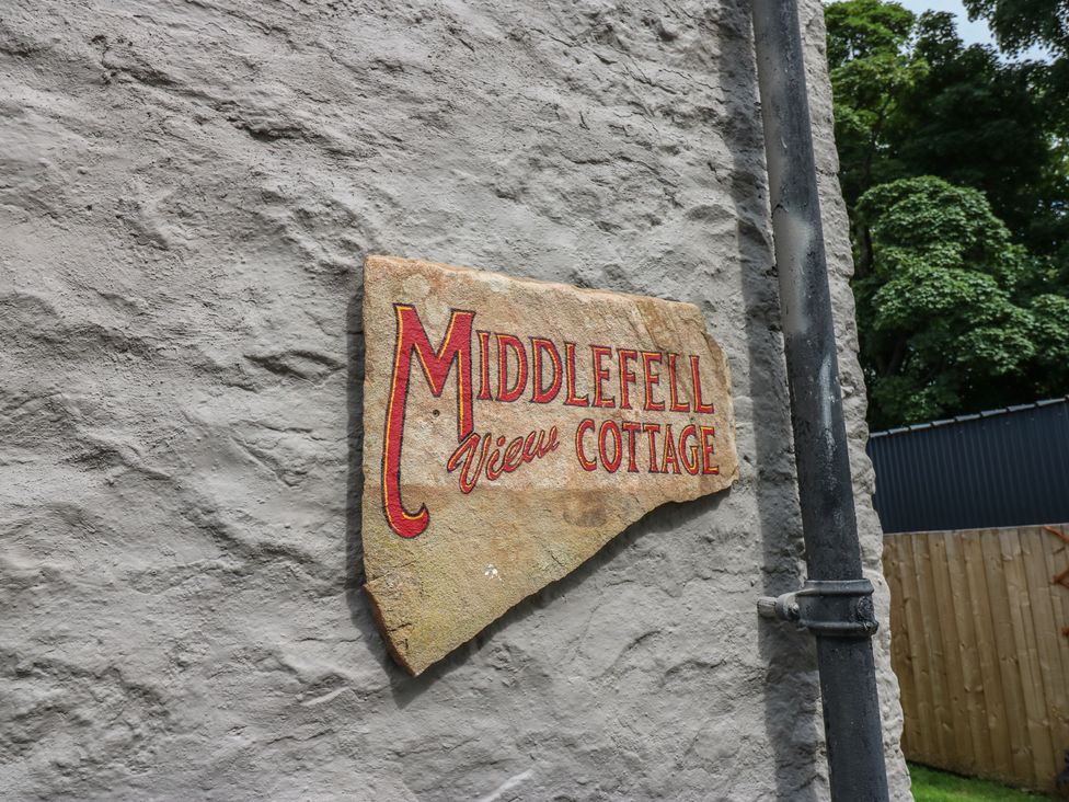 A sign reading Middlefell View Cottage on a stone wall at Middlefell View Cottage in Alston
