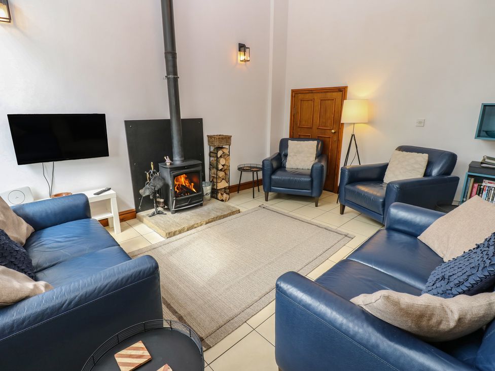 A living room with a fireplace and seating area at Middlefell View Cottage in Alston