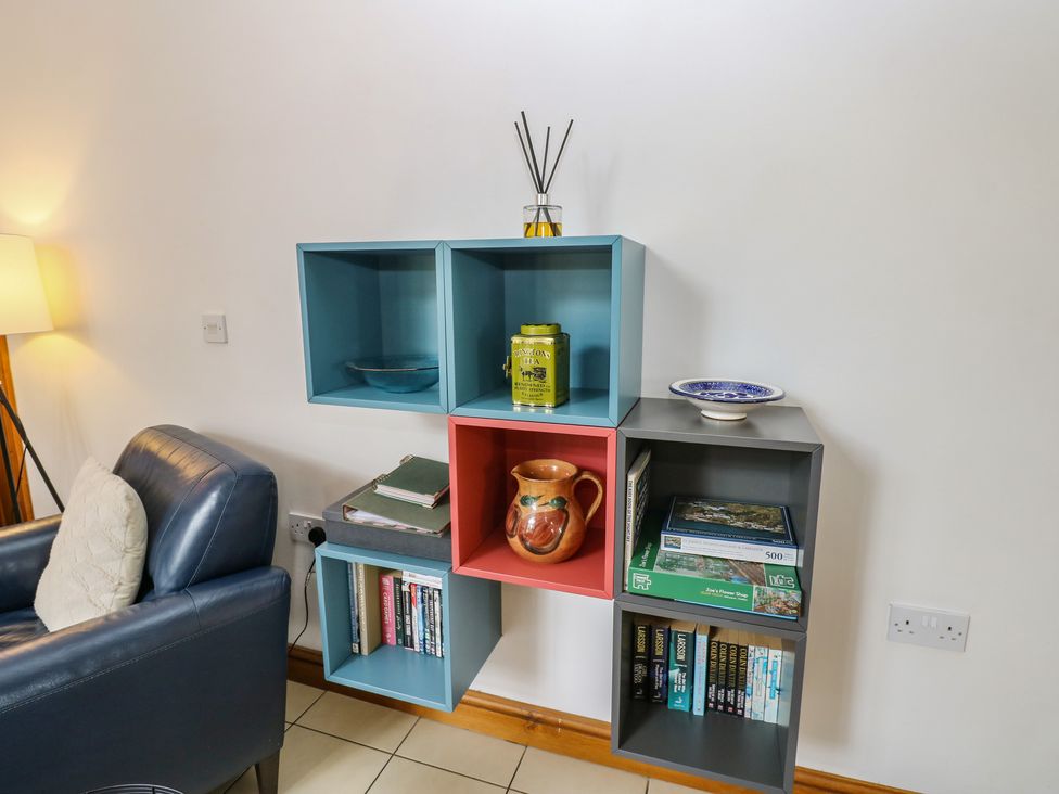 A shelf with books and decorative items at Middlefell View Cottage in Alston