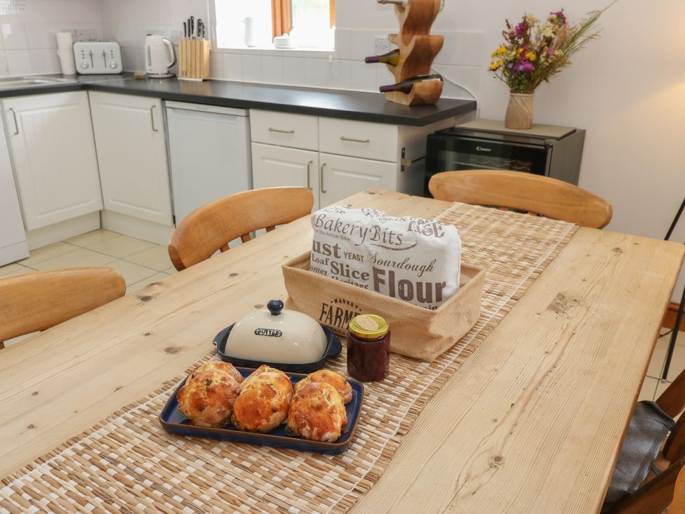 A kitchen with a table and bread rolls at Middlefell View Cottage in Alston