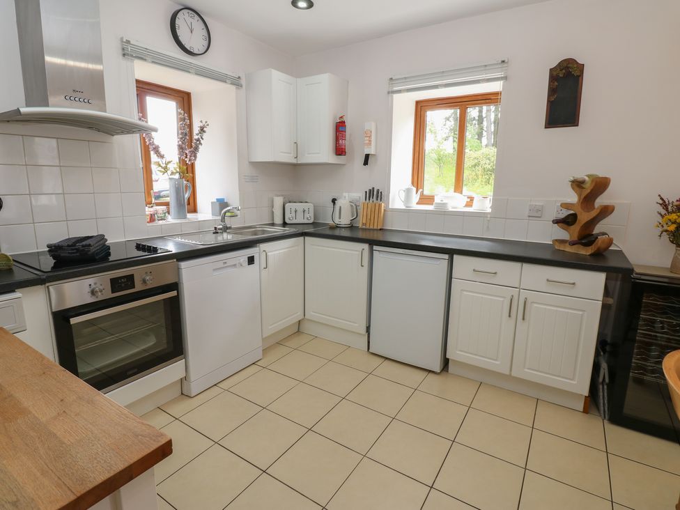 A kitchen with cabinets and appliances at Middlefell View Cottage Alston