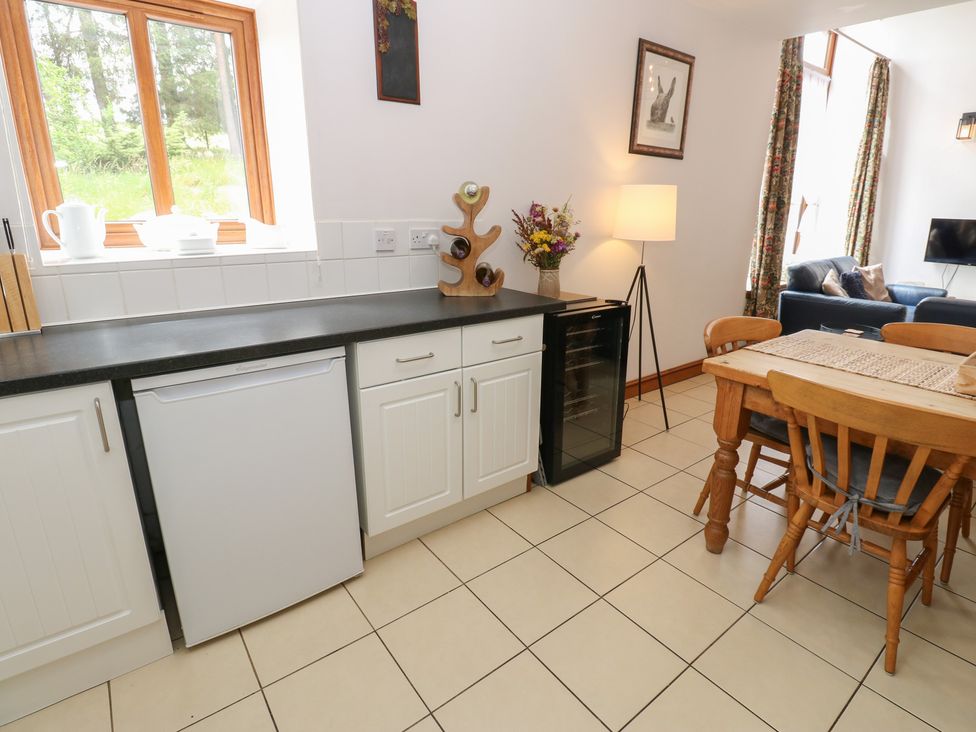 A kitchen with cabinets and a table at Middlefell View Cottage in Alston