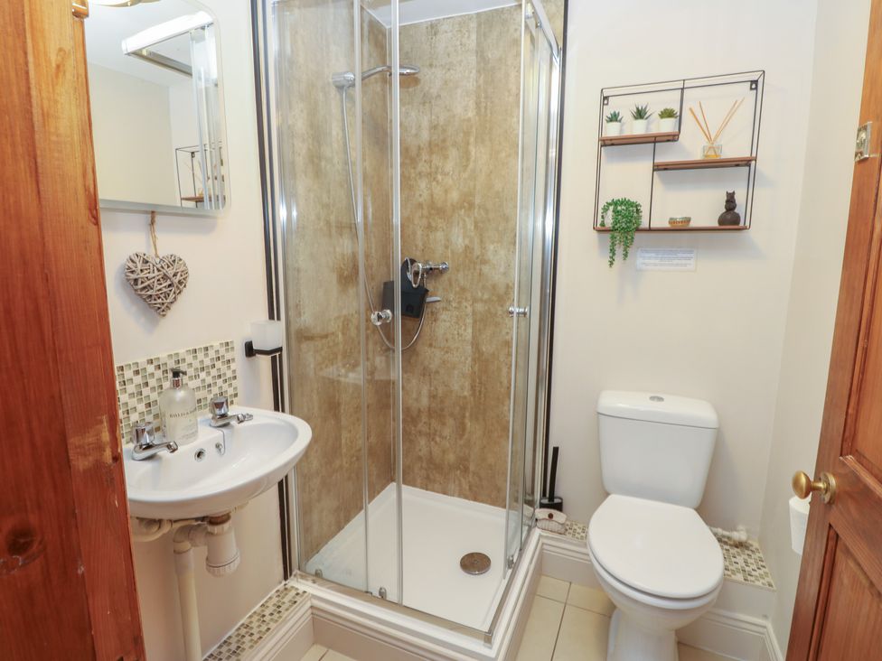 A bathroom with a shower enclosure and toilet at Middlefell View Cottage in Alston