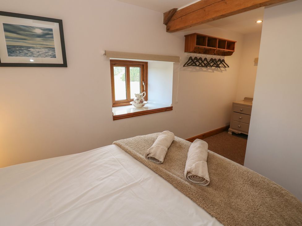 A bedroom with a bed and a dresser at Middlefell View Cottage in Alston