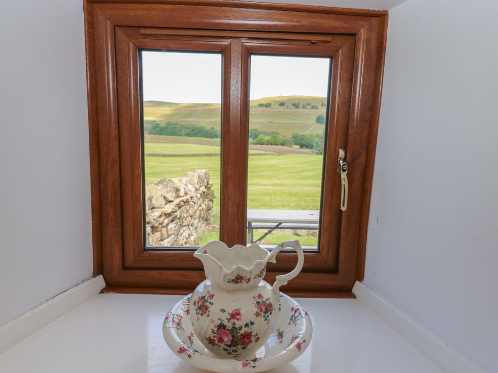 A window with a pitcher and bowl in front at Middlefell View Cottage in Alston