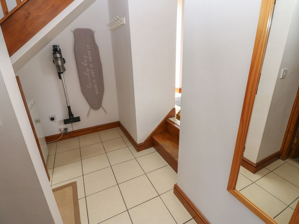 A hallway with a staircase and a vacuum cleaner at Middlefell View Cottage in Alston