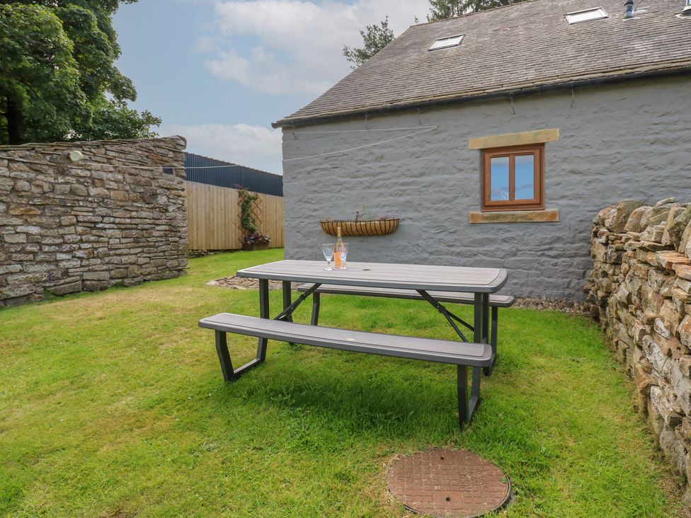 A garden with a table and benches at Middlefell View Cottage in Alston