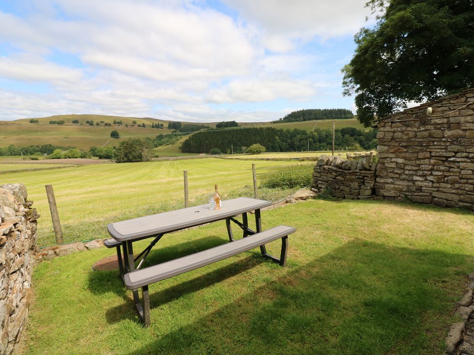 An outdoor area with a picnic table and bottle at Middlefell View Cottage in Alston