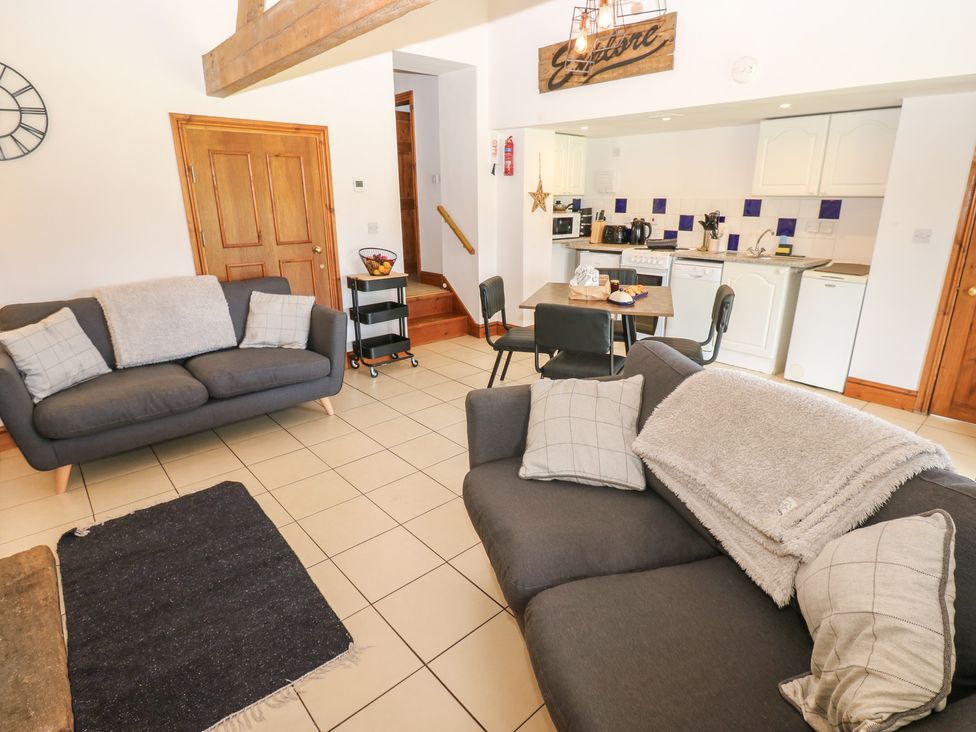 A living room with a sofa and dining area at Wellhope View Cottage in Alston