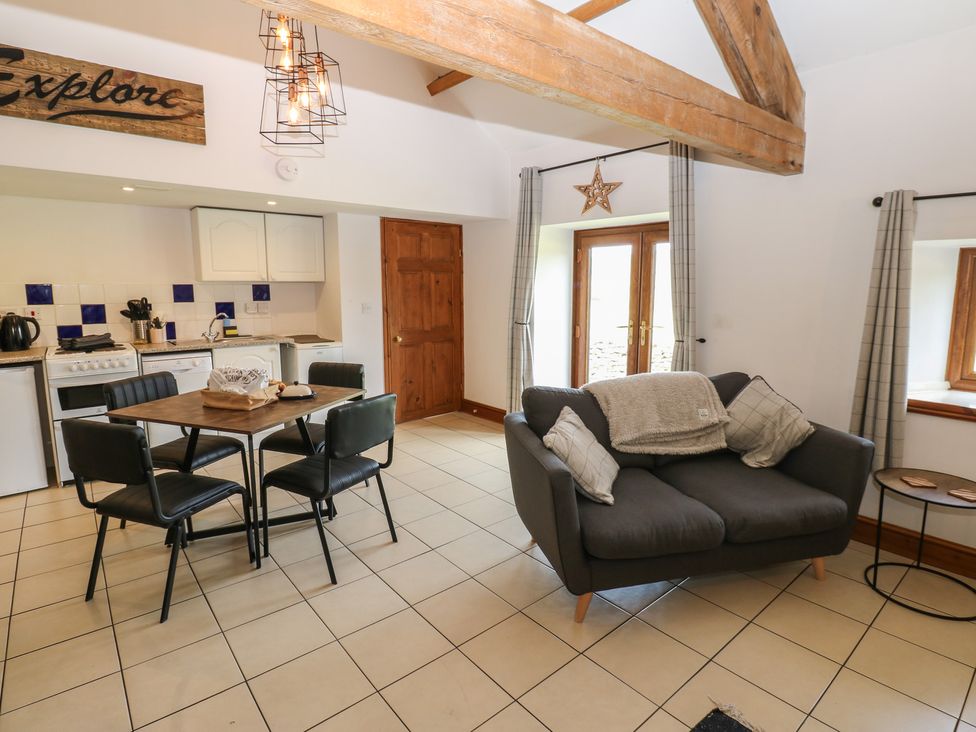 A kitchen and dining area with a table and chairs at Wellhope View Cottage in Alston