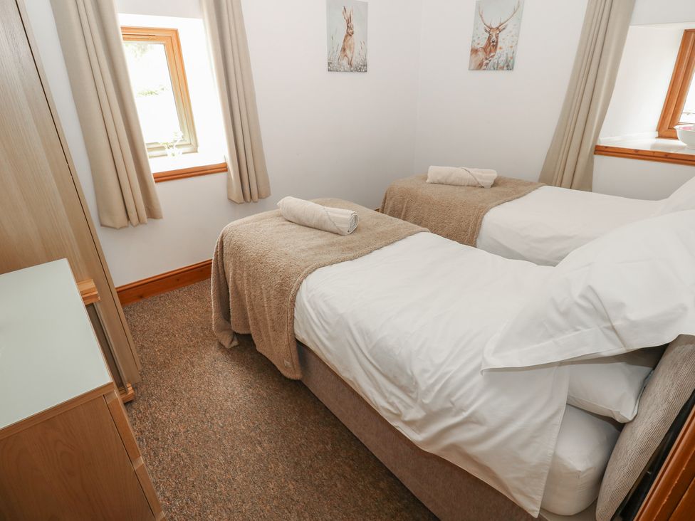 A bedroom with two single beds and a window at Wellhope View Cottage in Alston