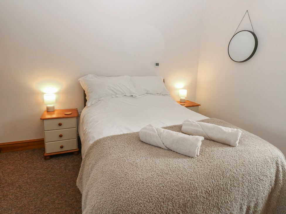 A bedroom with a bed and bedside table at Wellhope View Cottage in Alston