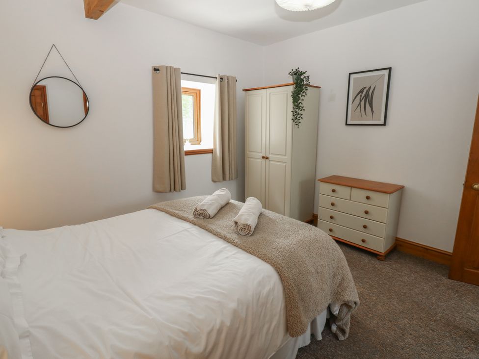 A bedroom with a bed and wardrobe at Wellhope View Cottage in Alston