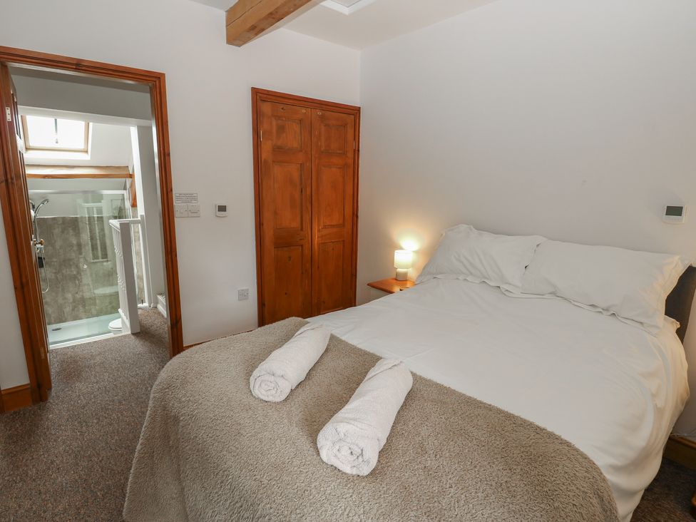 A bedroom with a bed and adjoining bathroom at Wellhope View Cottage in Alston