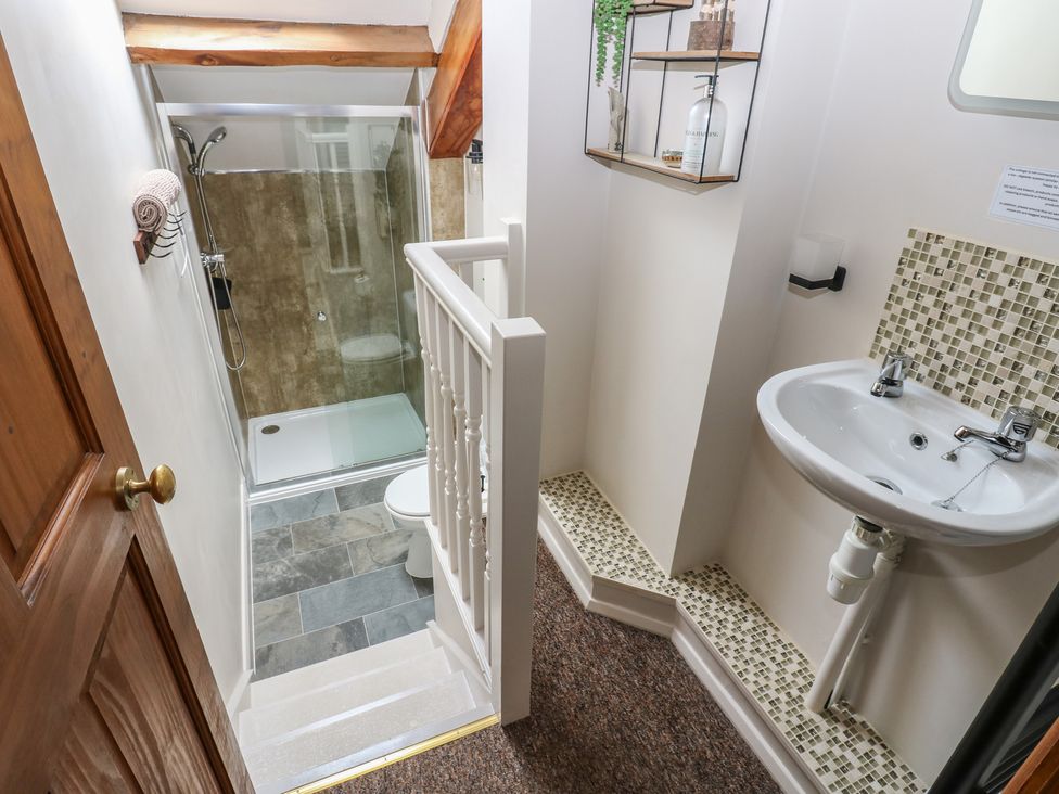 A bathroom featuring a shower, toilet, and sink at Wellhope View Cottage in Alston