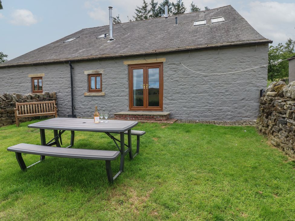 A picnic table and bench outside a cottage at Wellhope View Cottage in Alston
