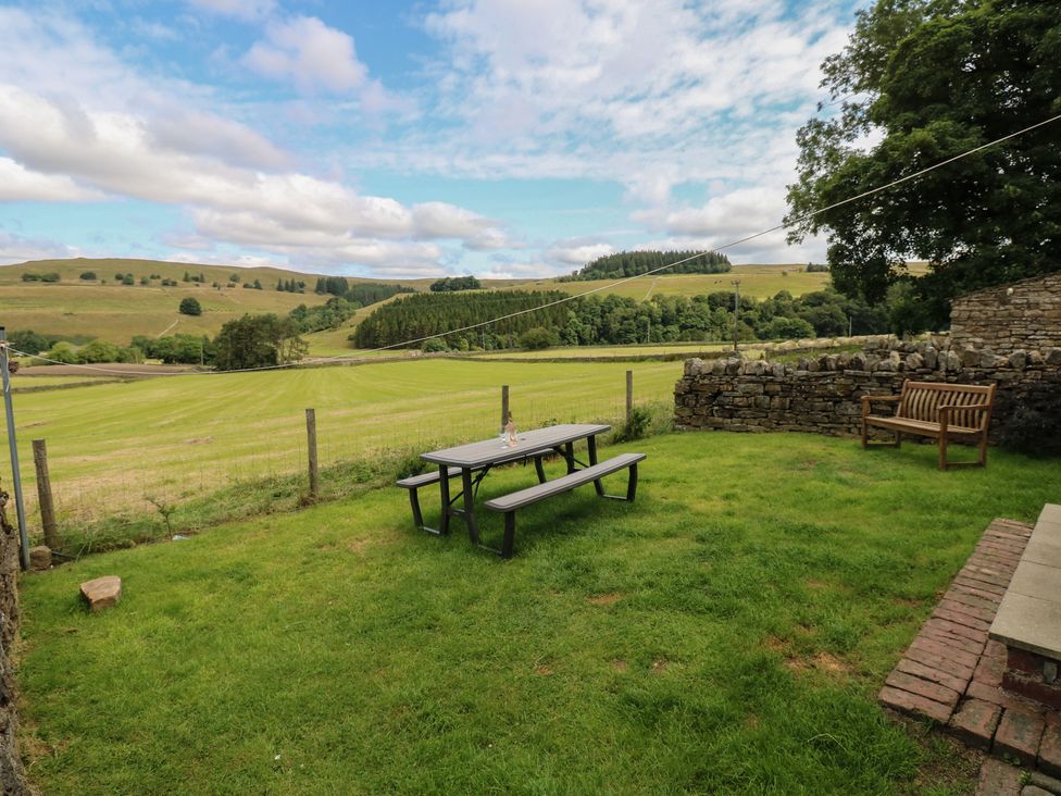 A garden with a table and bench at Wellhope View Cottage Alston