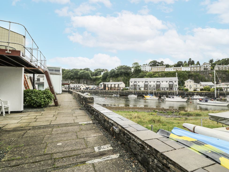 An outdoor view of a waterfront with buildings and boats at Harbwr Hideaway in Porthmadog