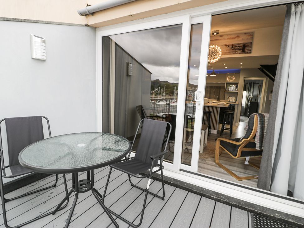 An outdoor area with a table and chairs at Harbwr Hideaway in Porthmadog