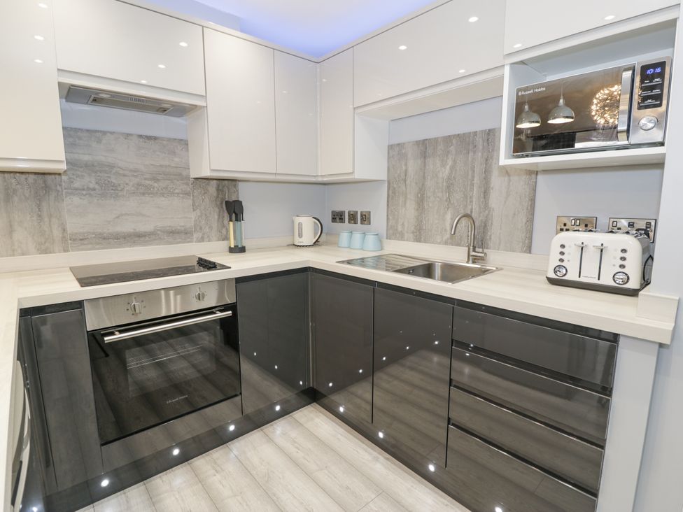 A kitchen with appliances and modern fixtures at Harbwr Hideaway in Porthmadog