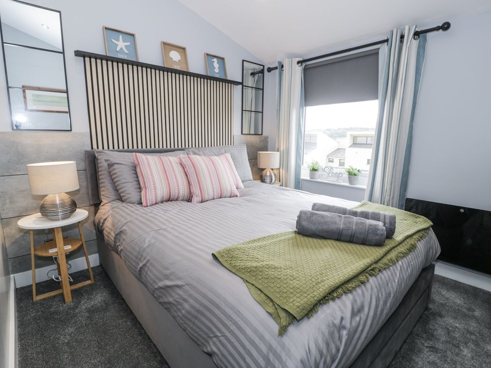 A bedroom with bed and window at Harbwr Hideaway in Porthmadog