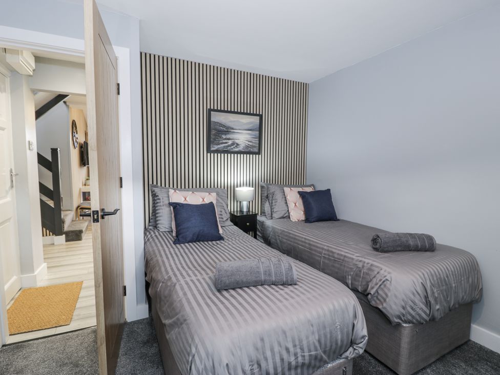 A bedroom with two single beds at Harbwr Hideaway in Porthmadog
