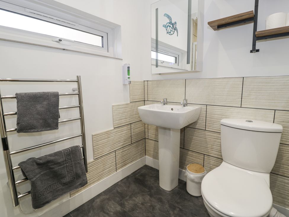 A bathroom with a sink and toilet at Harbwr Hideaway in Porthmadog