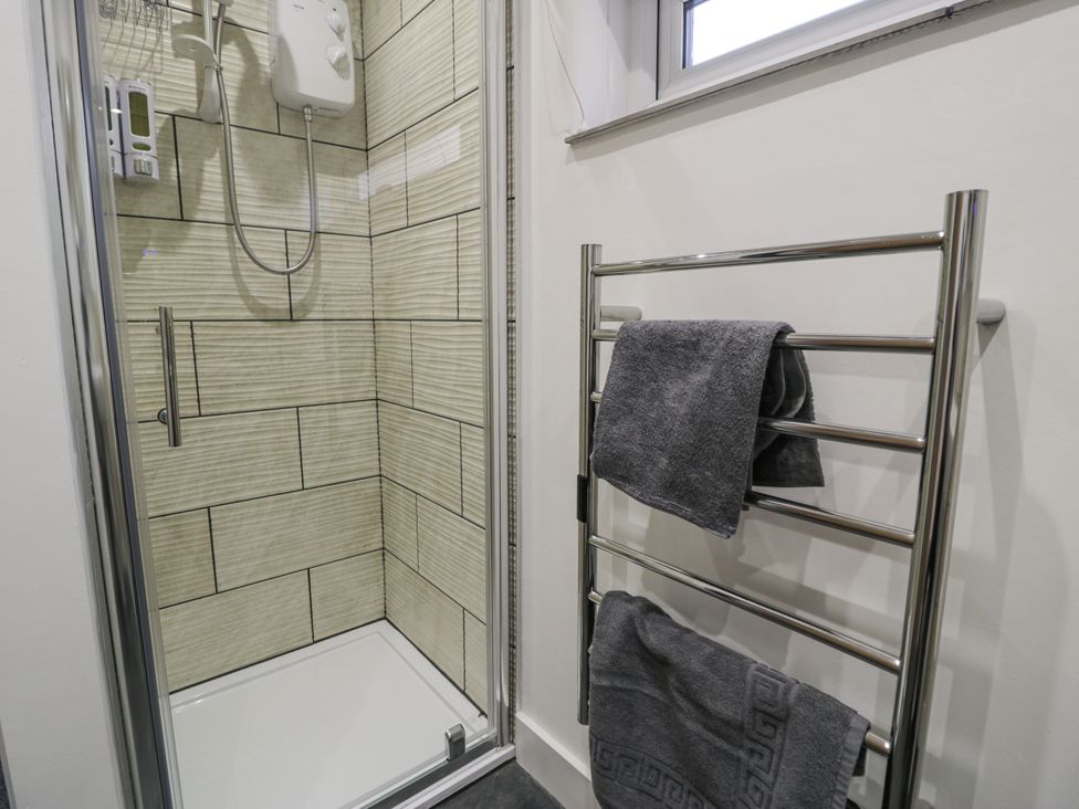 A shower and towel rail in a bathroom at Harbwr Hideaway in Porthmadog