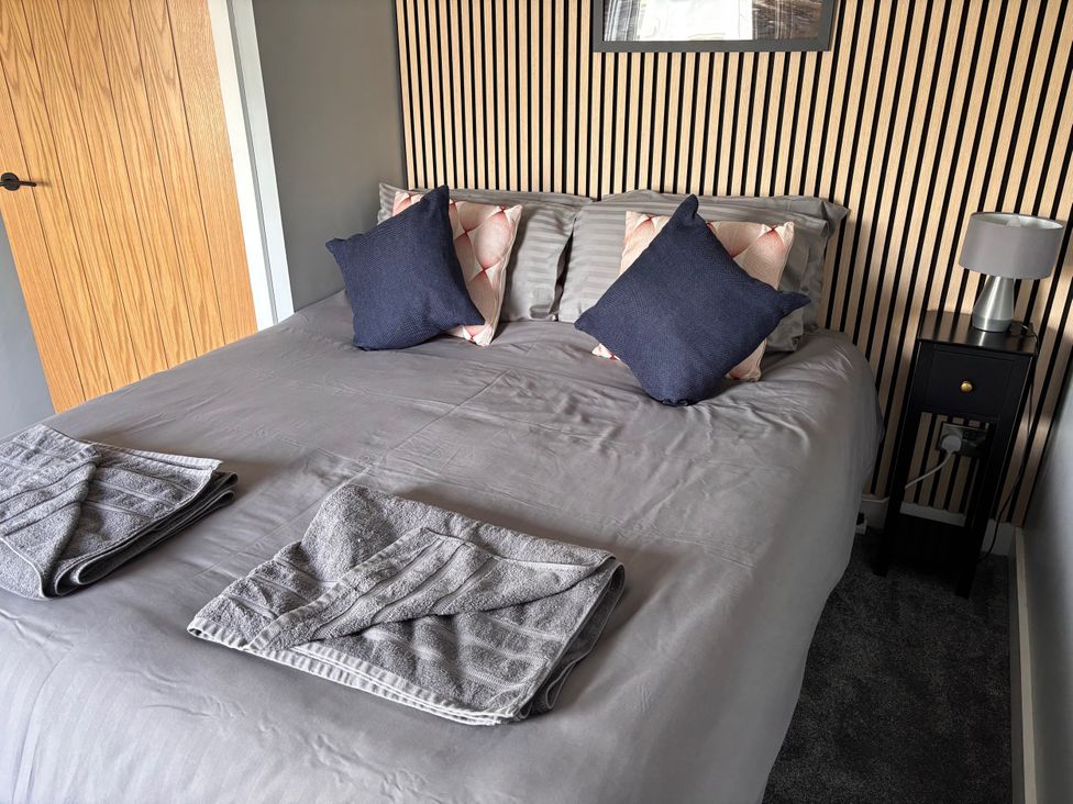 A bedroom with a bed and lamps at Harbwr Hideaway in Porthmadog