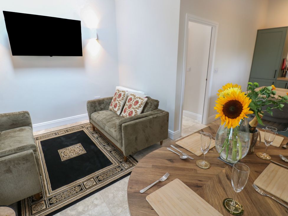 A dining room with a sofa and a table with cutlery at Antoninus Barn 2 Ebchester