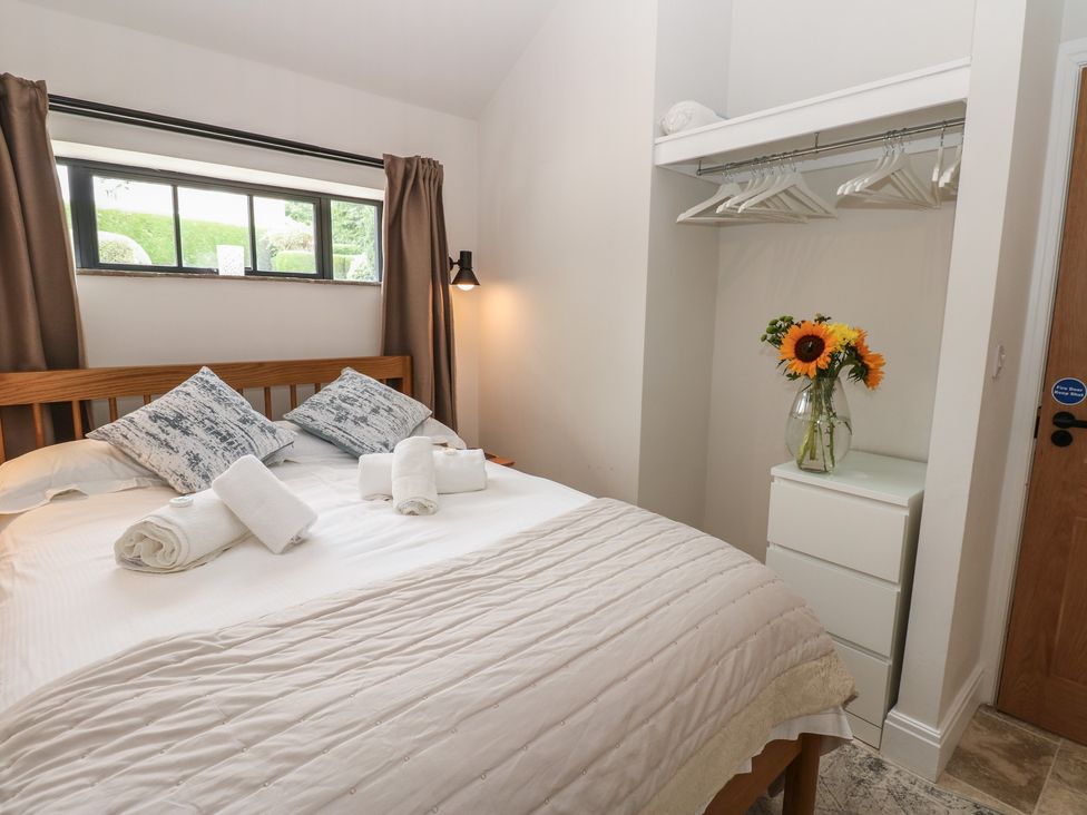 A bedroom with a bed and flowers in a vase at Antoninus Barn 2 Ebchester