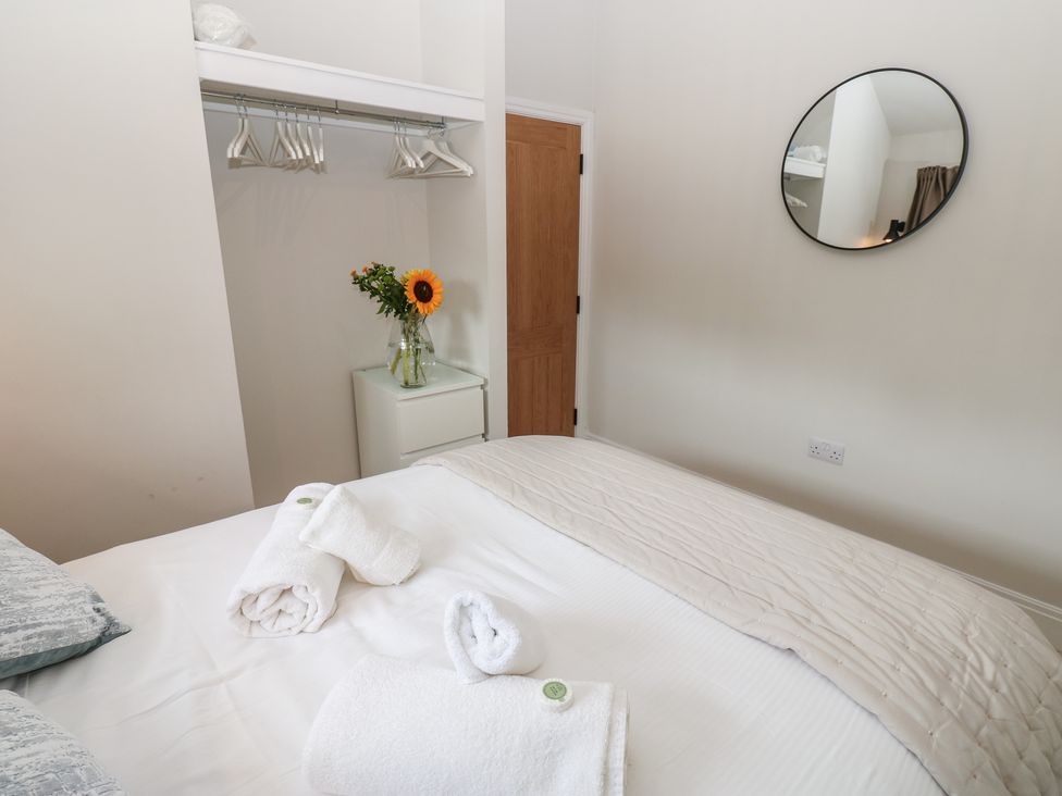 A bedroom with a bed and a flower arrangement at Antoninus Barn 2, Ebchester