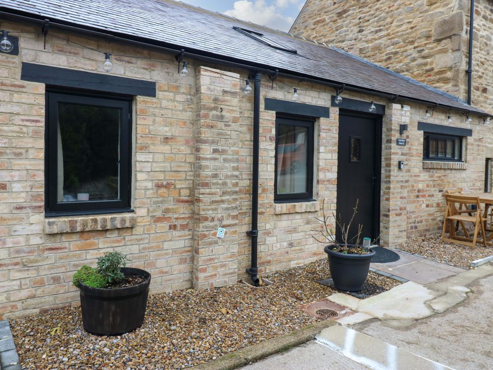 A stone exterior with door, window, table and chairs at Antoninus Barn 2 Ebchester