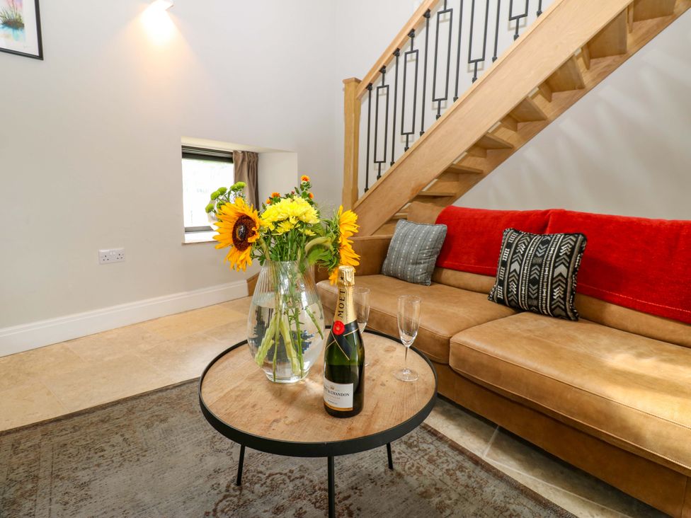 A living room with a sofa, table, and flowers at Marcus Barn 3 in Ebchester