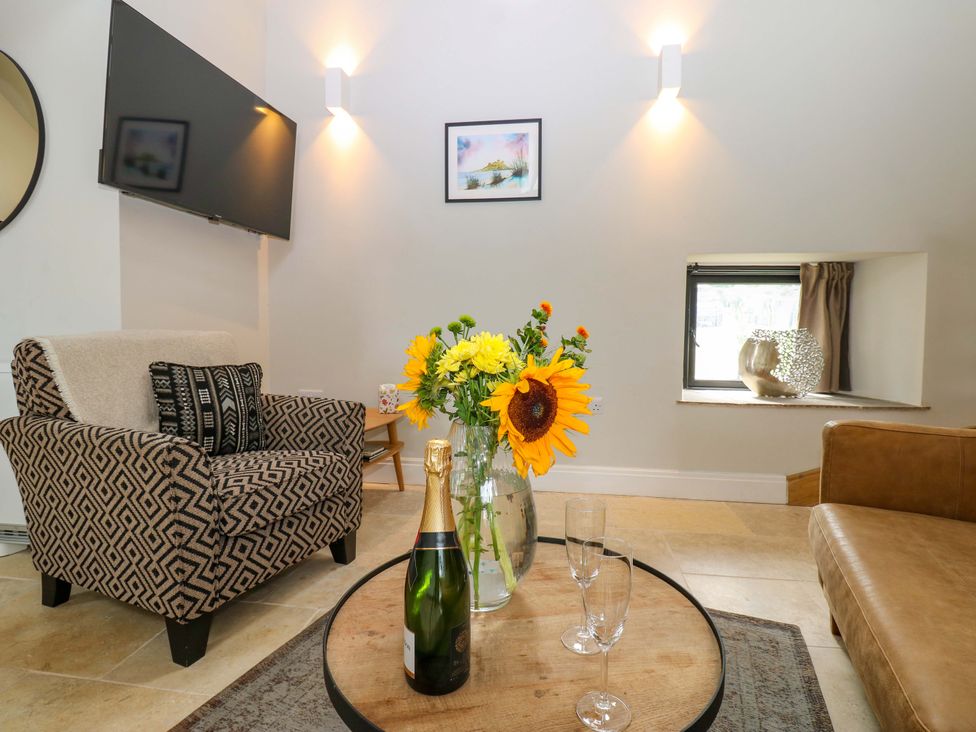 A living room with flowers and champagne at Marcus Barn 3 Ebchester