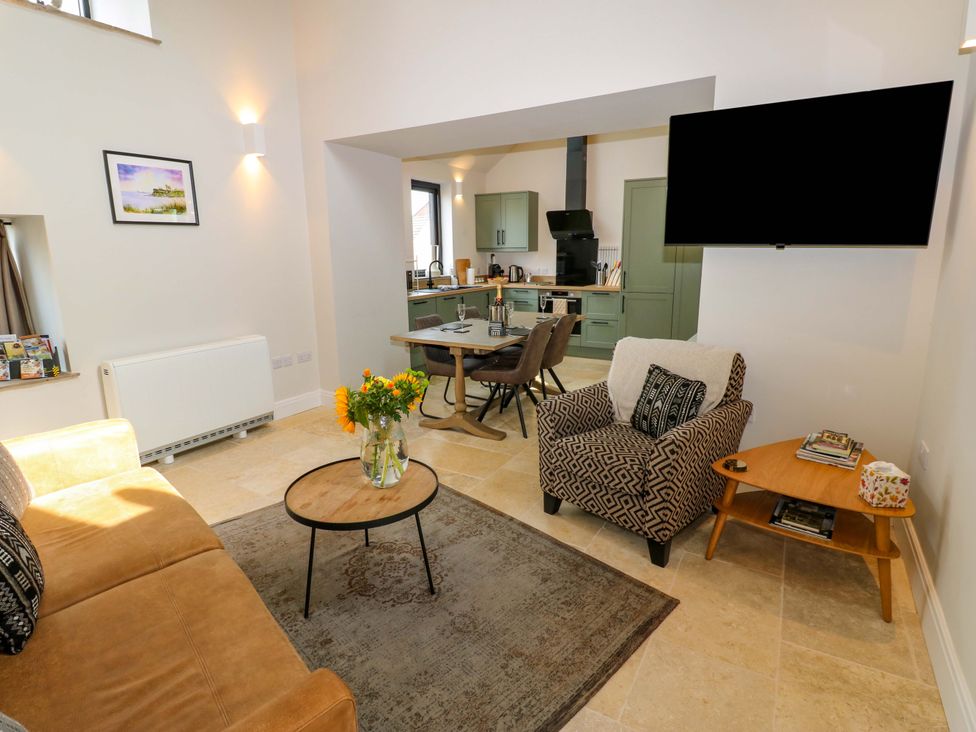 A living room with a sofa, coffee table and kitchen area at Marcus Barn 3 Ebchester