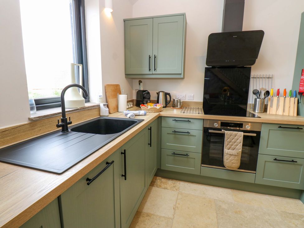 A kitchen with cabinets, a sink, and an oven at Marcus Barn 3 in Ebchester