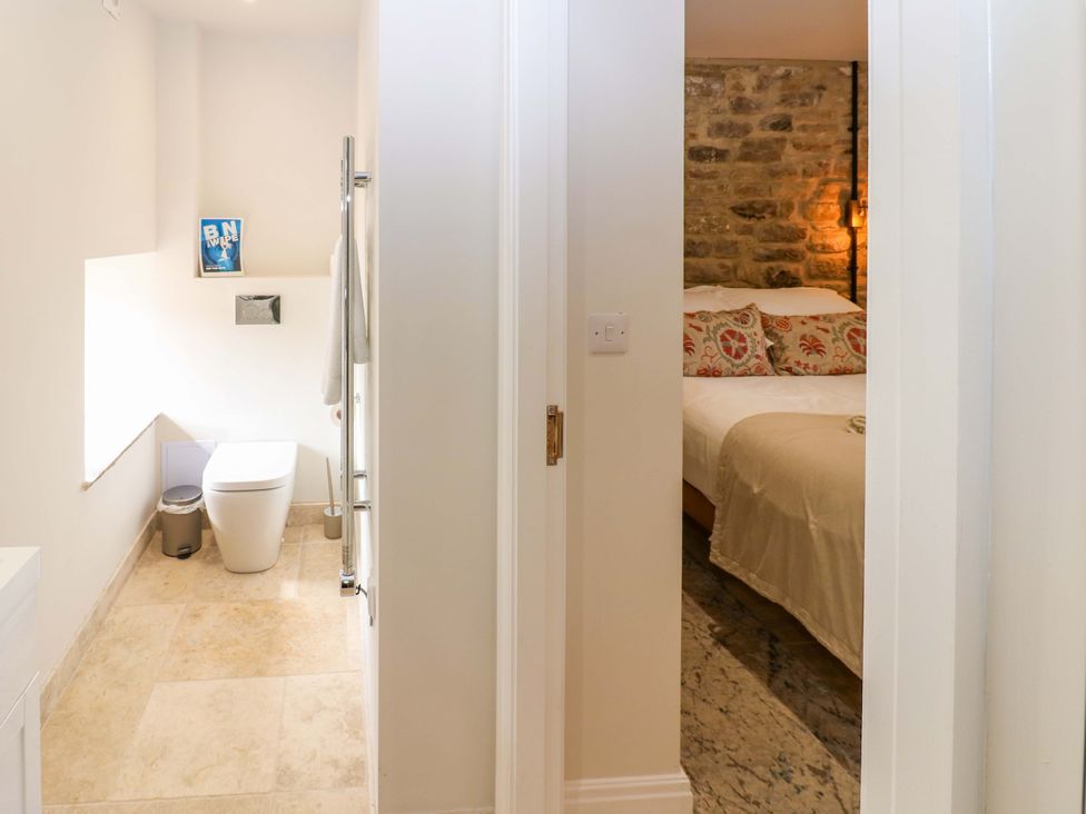 A bathroom with a toilet and sink leading to a bedroom at Marcus Barn 3 Ebchester