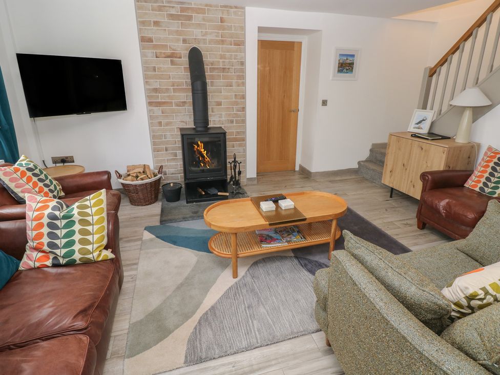 A living room with a fireplace and seating area at Folly Cottage in Llanteg near Saundersfoot