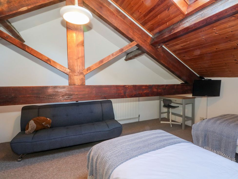 A bedroom with a sofa bed, table and chair at TOB Grave Prospect
