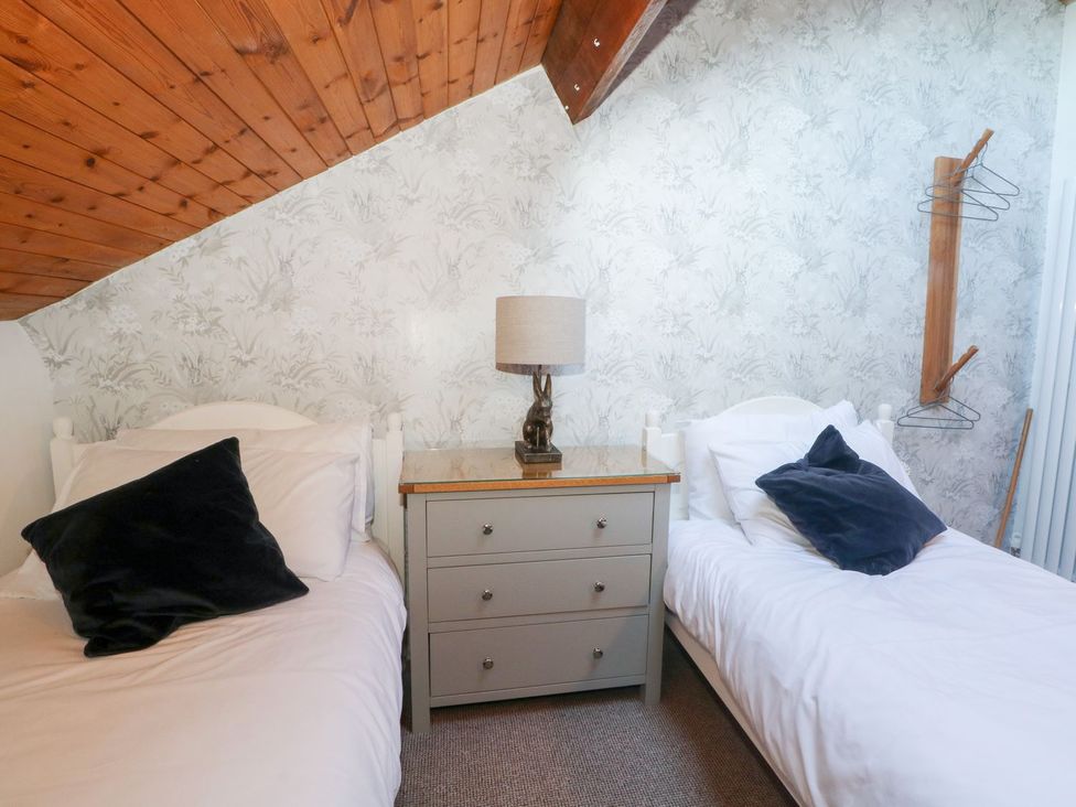 A bedroom with two beds and a lamp on a nightstand at TOB Grave Prospect