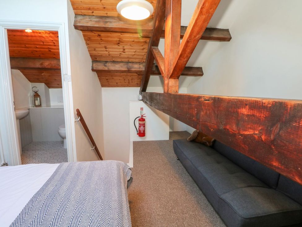 A loft with wooden beams and a sofa at TOB Grave Prospect