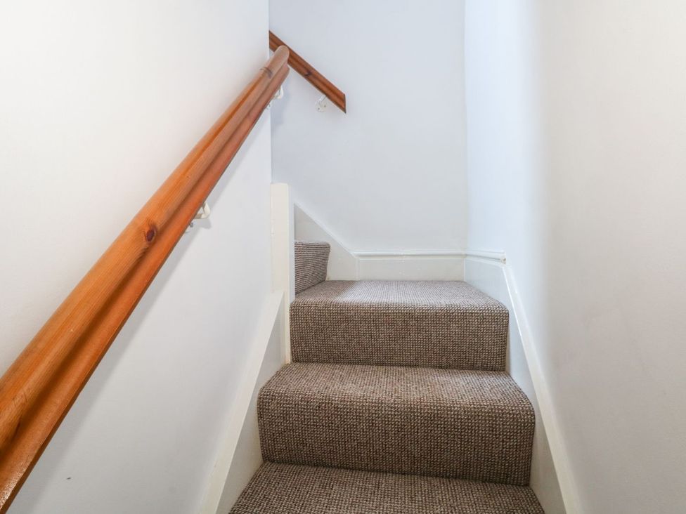 A staircase with carpet and a wooden handrail at TOB Grave Prospect